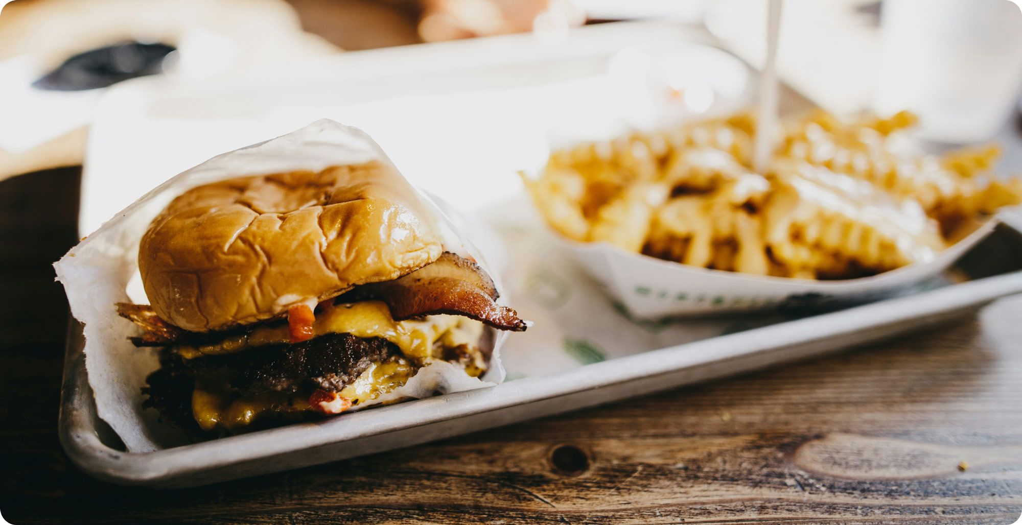 Image of a hamburger and fries on a tray: to illustrate complementary products/goods in cross price elasticity.