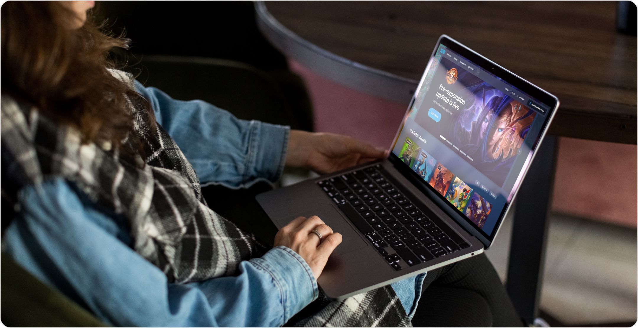 A woman with a laptop open to the Blizzard website