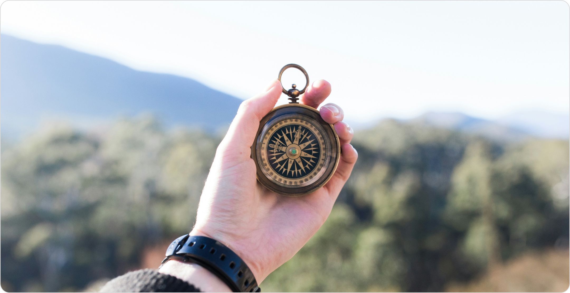 A hand holding a compass: signifying the guidance of prescriptive analytics