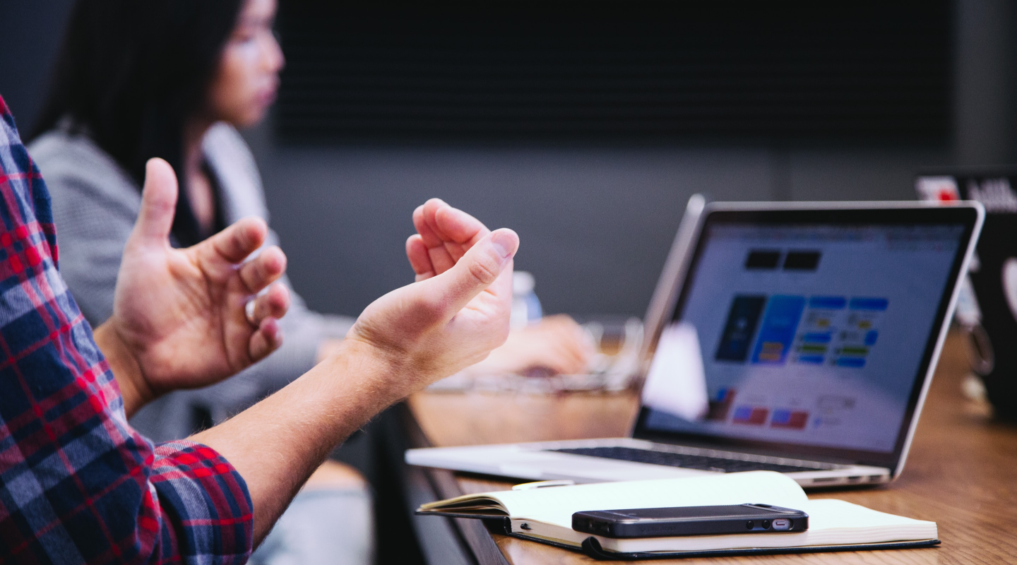 A man in a meeting, gesturing with his hands as he talks about the MaxDiff Analysis results