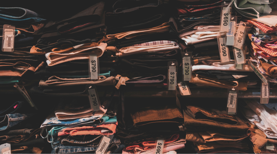 Piles of clothes with price tags, to illustrate pricing research with conjoint analysis