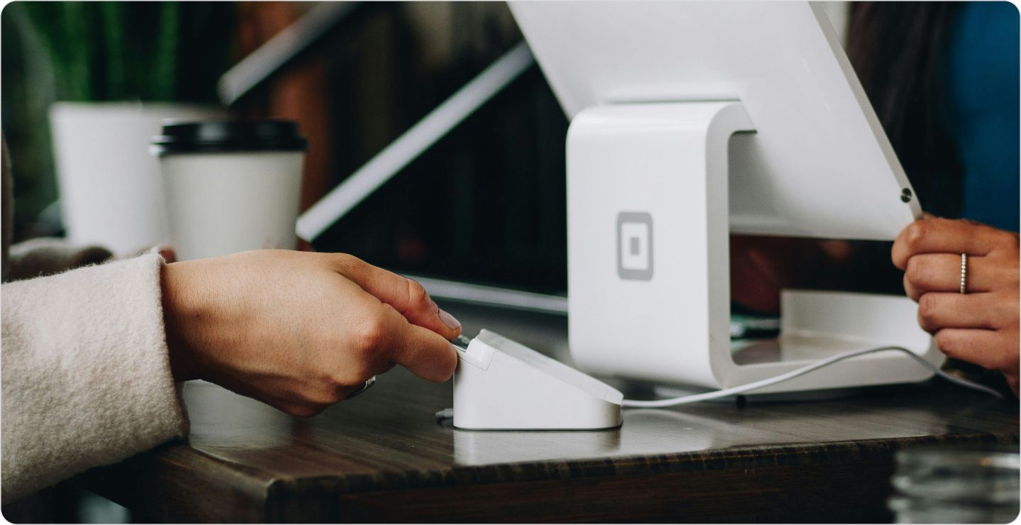 A person using a credit card at a register: illustrating buying behavior.