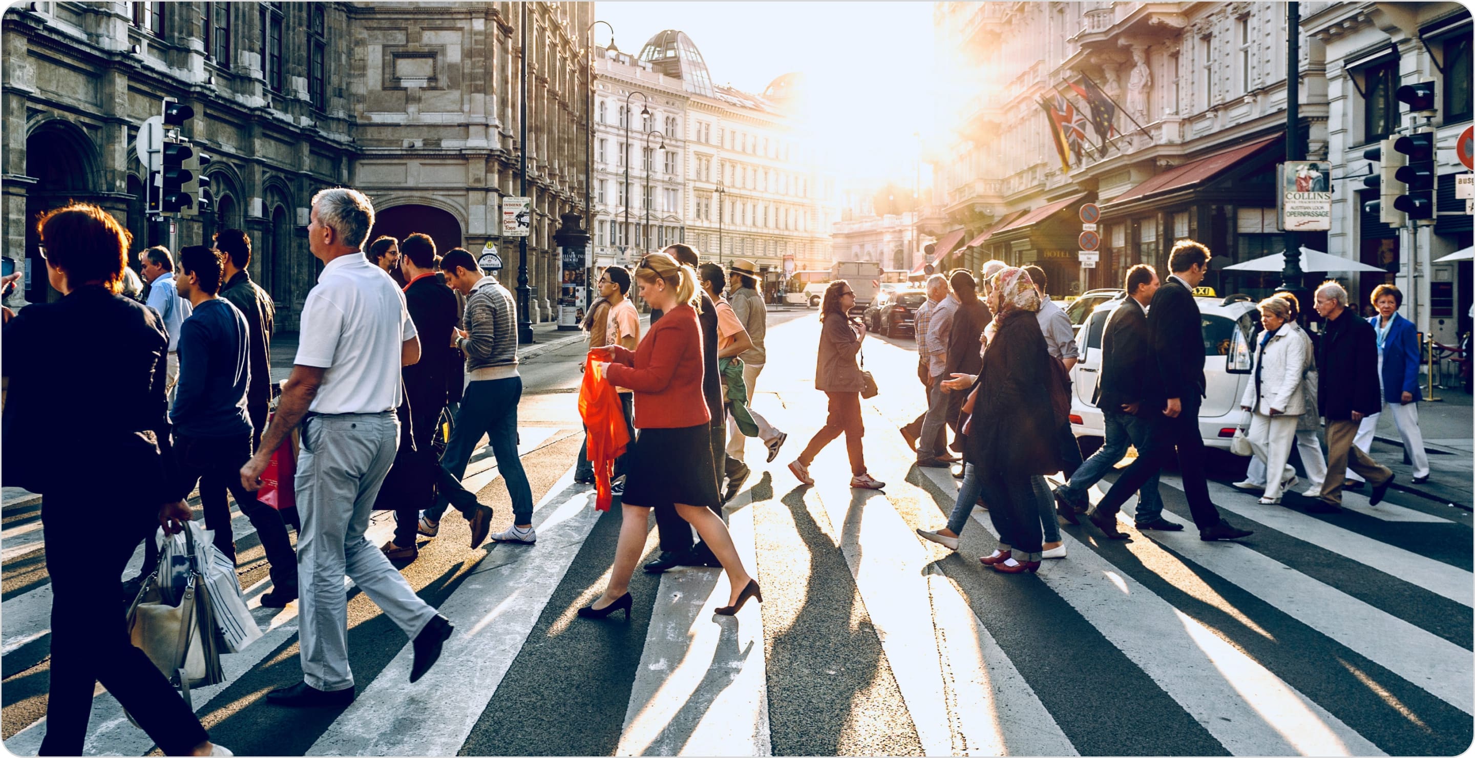 Crowd of people walking across a street. Find your customers by creating Target Customer Profiles. 