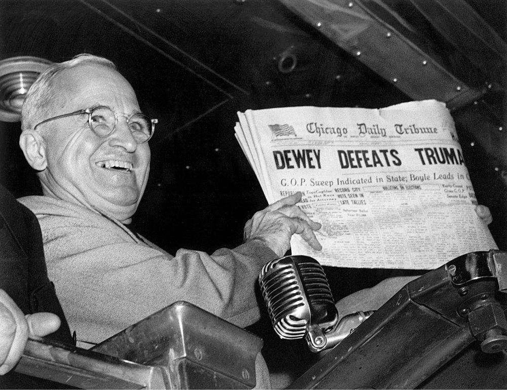 Harry Truman holding a newspaper that reads 