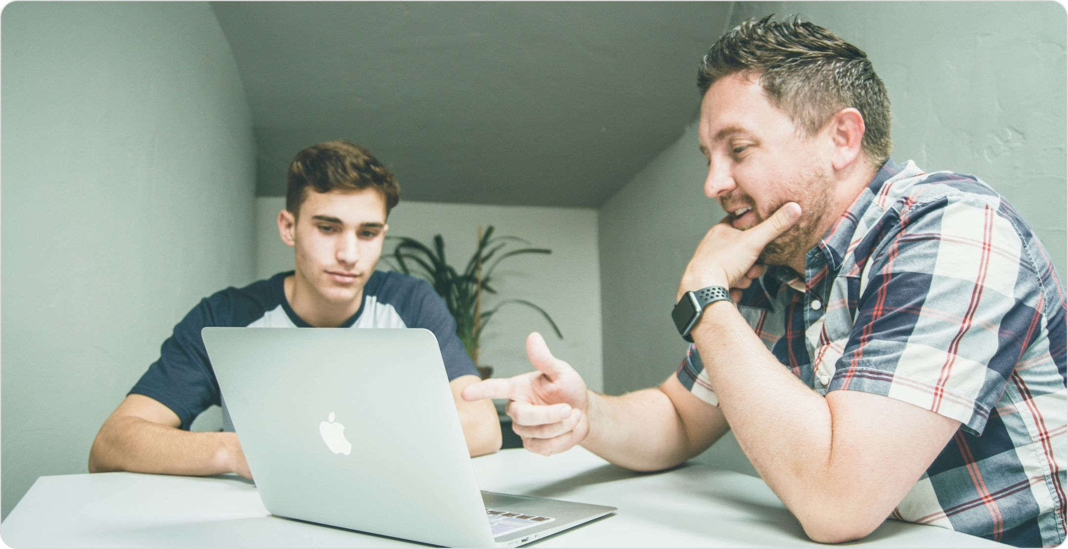 Qualitative data interview between two men at a table with a laptop.